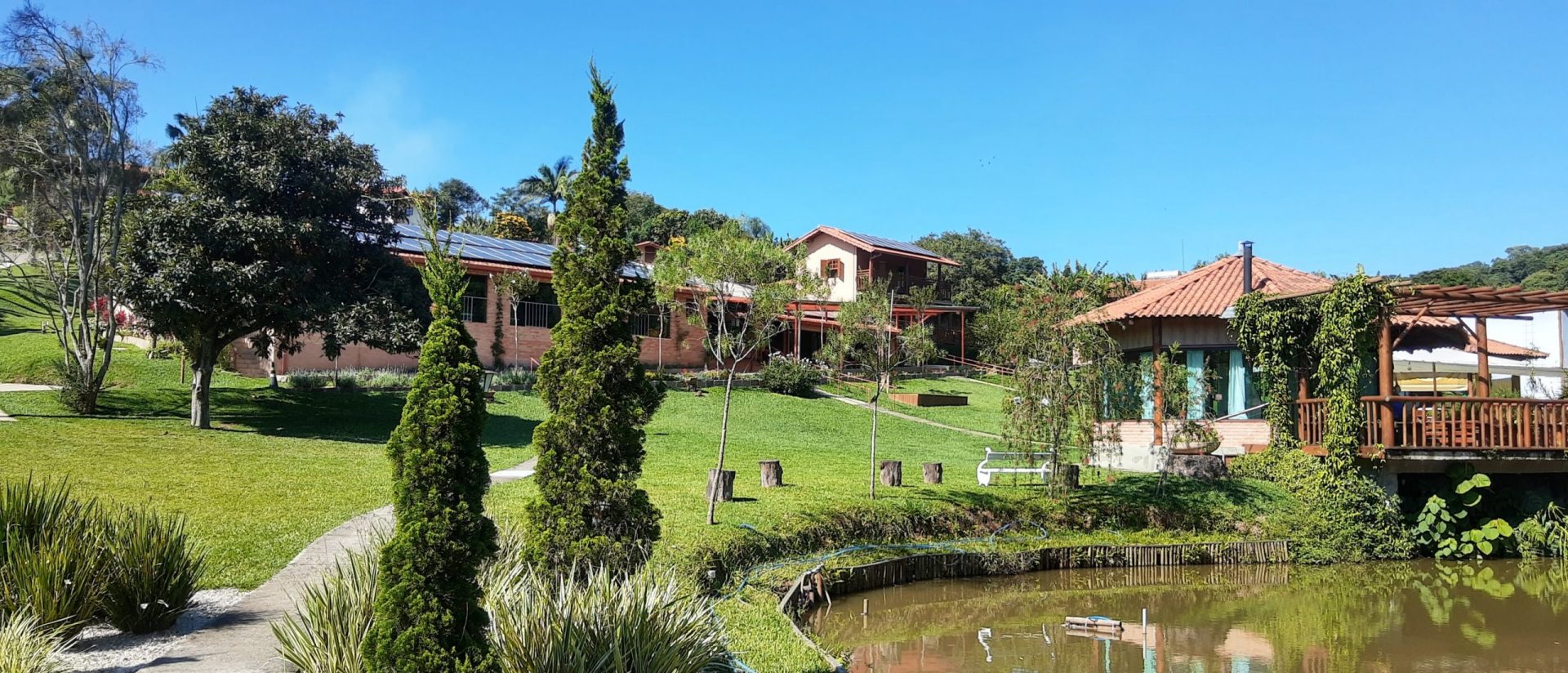 Vista da propriedade com lago natural e montanhas ao fundo